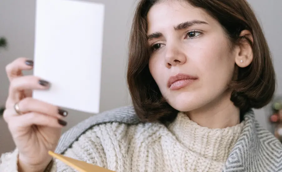 Mujer mirando una fotografia mientras procesa el duelo de una infidelidad