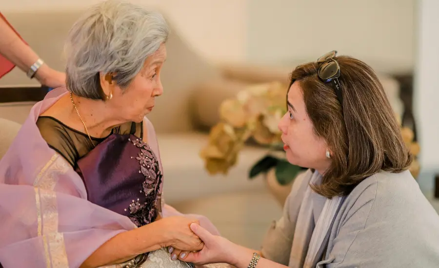 Dos mujeres mayores tomandose de las manos con apoyo