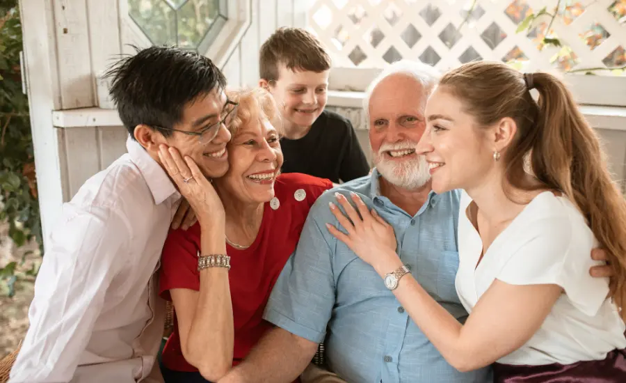 Familia multigeneracional abrazandose y sonriendo