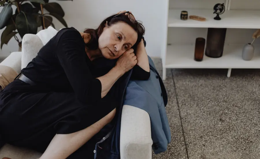 Mujer mayor triste sola en el sofa