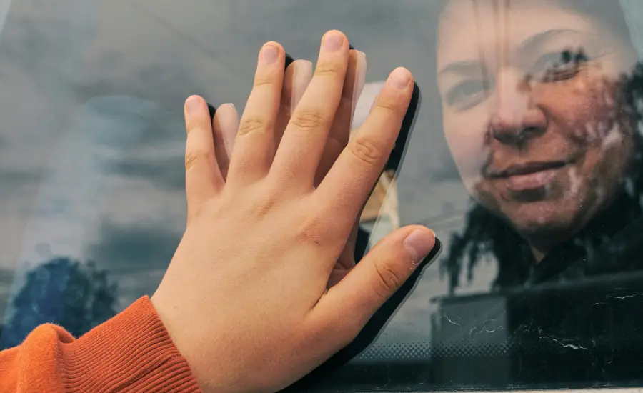 Despedida migrante mano en ventana del auto