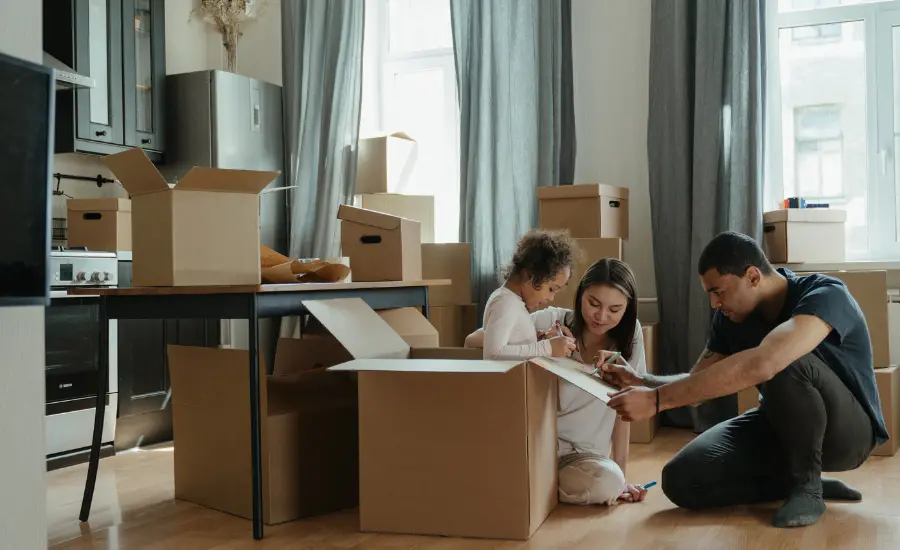 Familia migrante desempacando cajas nuevo hogar