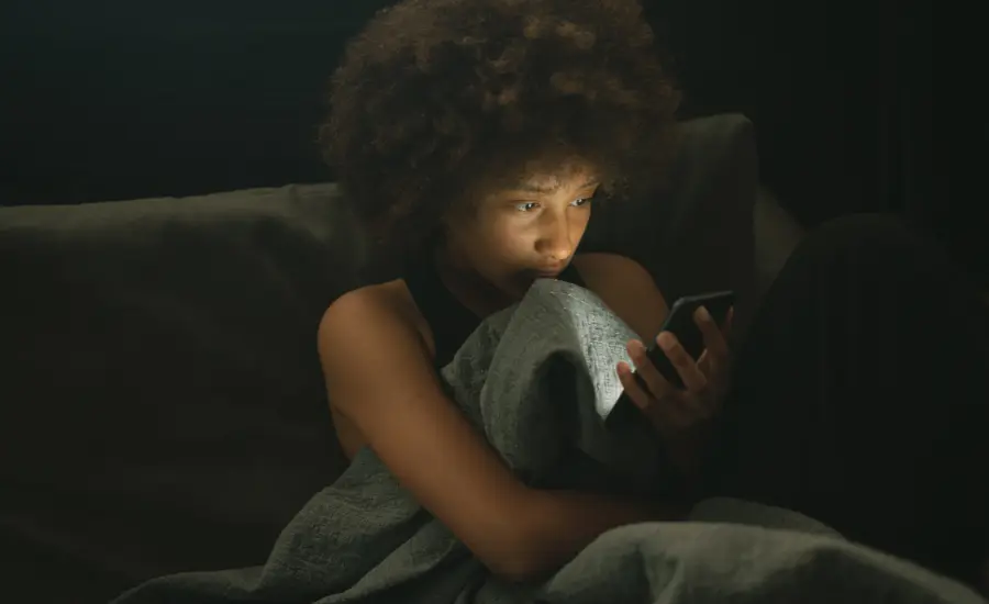 Mujer migrante aislada revisando celular de noche
