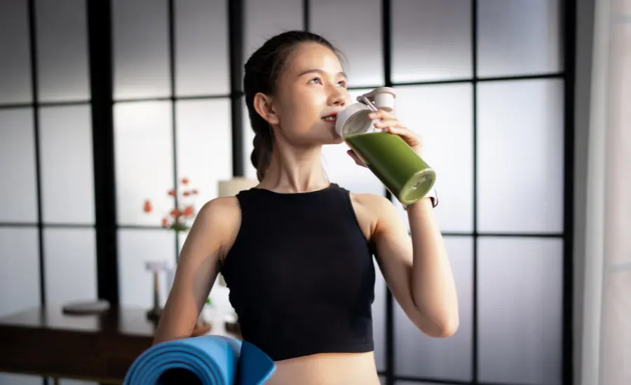 Mujer con batido verde y mat de yoga estilo de vida saludable
