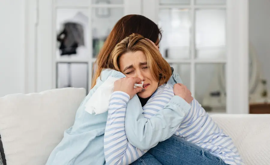 Dos personas abrazadas brindandose consuelo durante el duelo